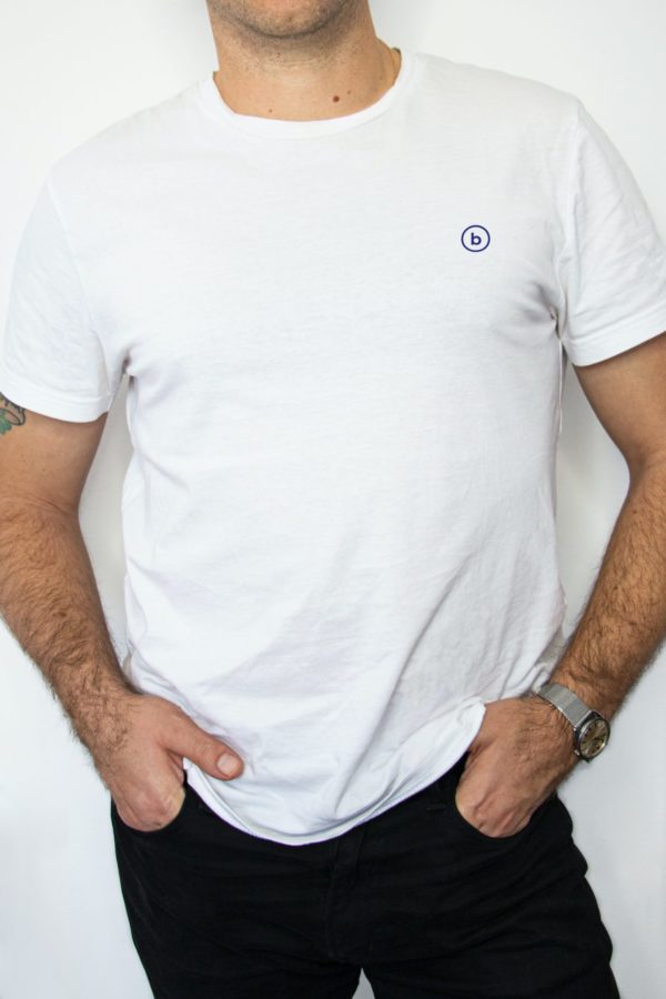 man wearing white crew-neck shirt and black denim jeans with hands in pocket