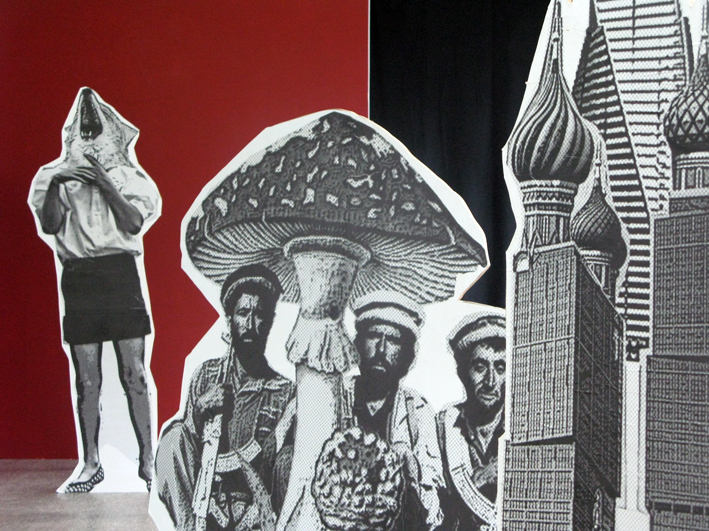 B&W cutout props of a large mushroom, some Russian building and 3 men