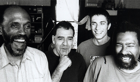 A B&W portrait of four members of TEST, all smiling