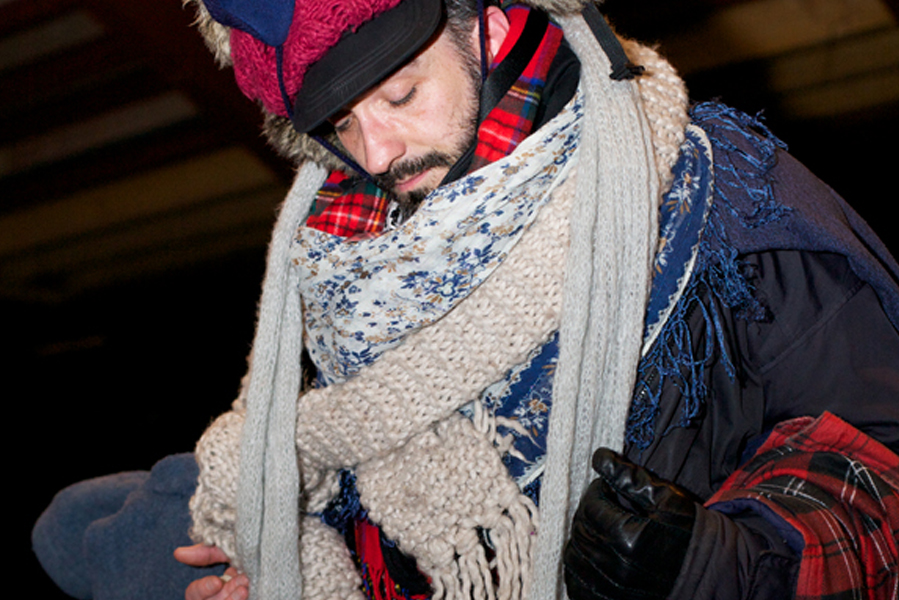 Man covered in a jumble of jumpers and scarves