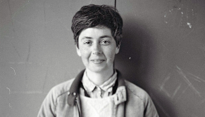 A portrait of Emma Hedditch in front of a grey wall