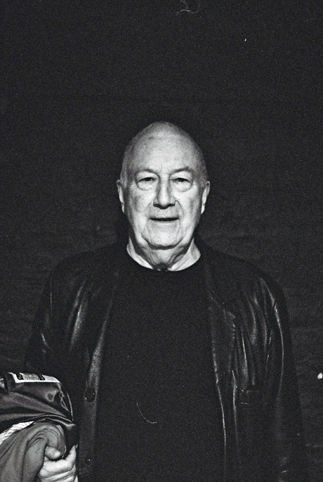 Portrait of John Tilbury in front of a dark wall