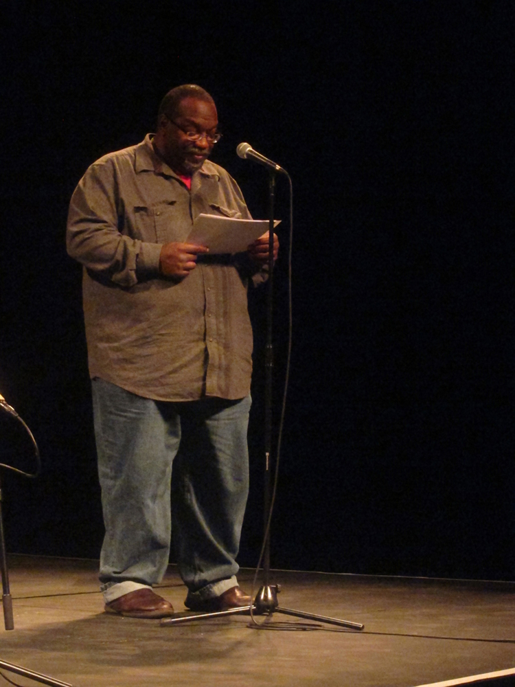 Fred Moten reads poetry at a microphone