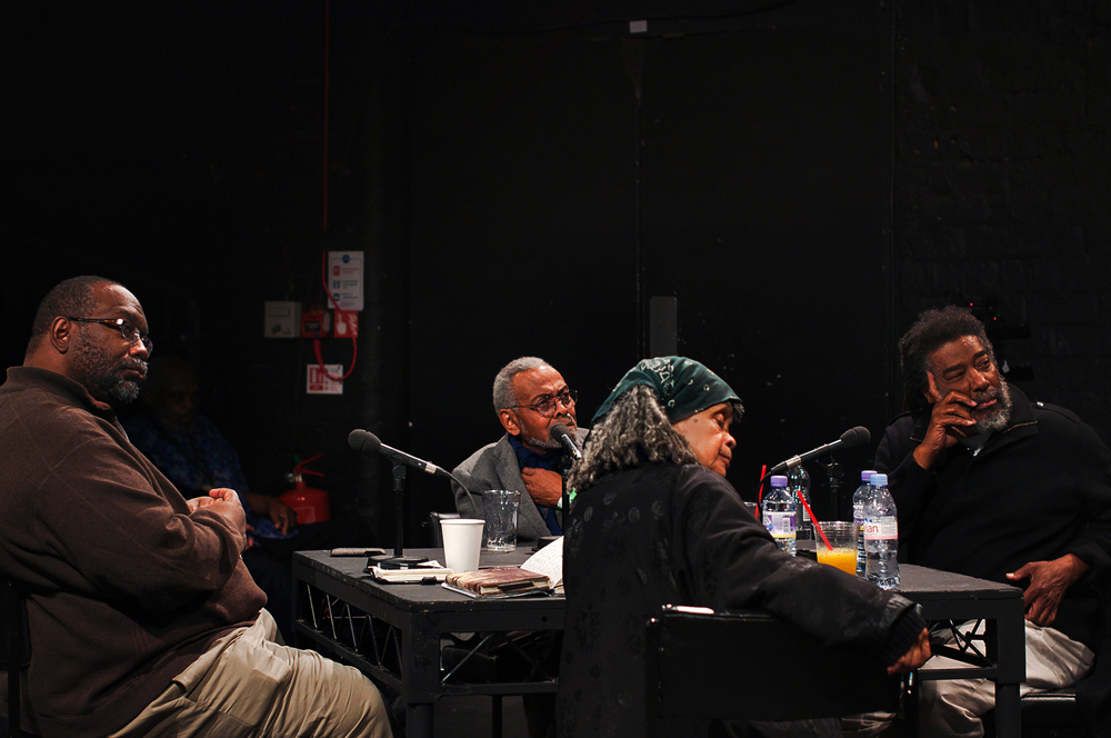 Four folks sit around a table looking out of frame to someone asking a question