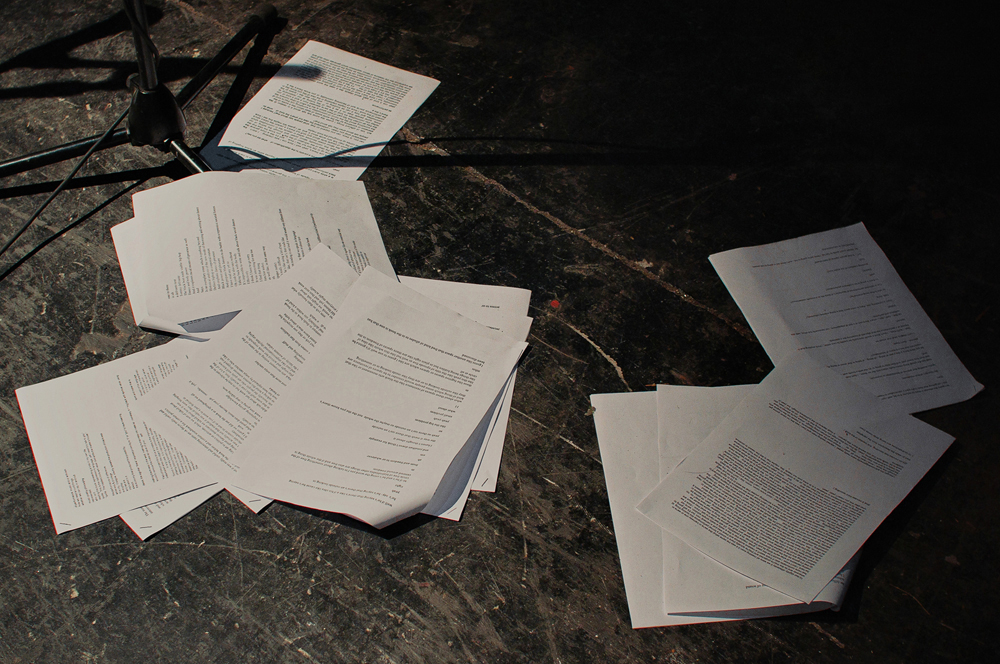 Script papers are strewn across a black floor