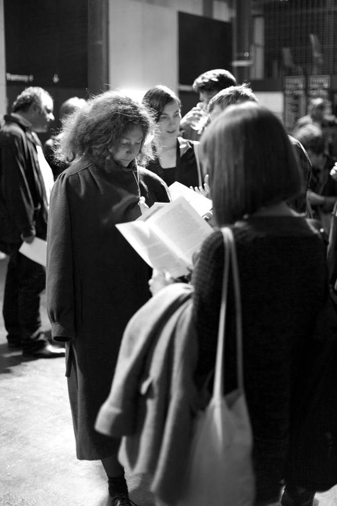 Audience members read the handout after the performance in a foyer