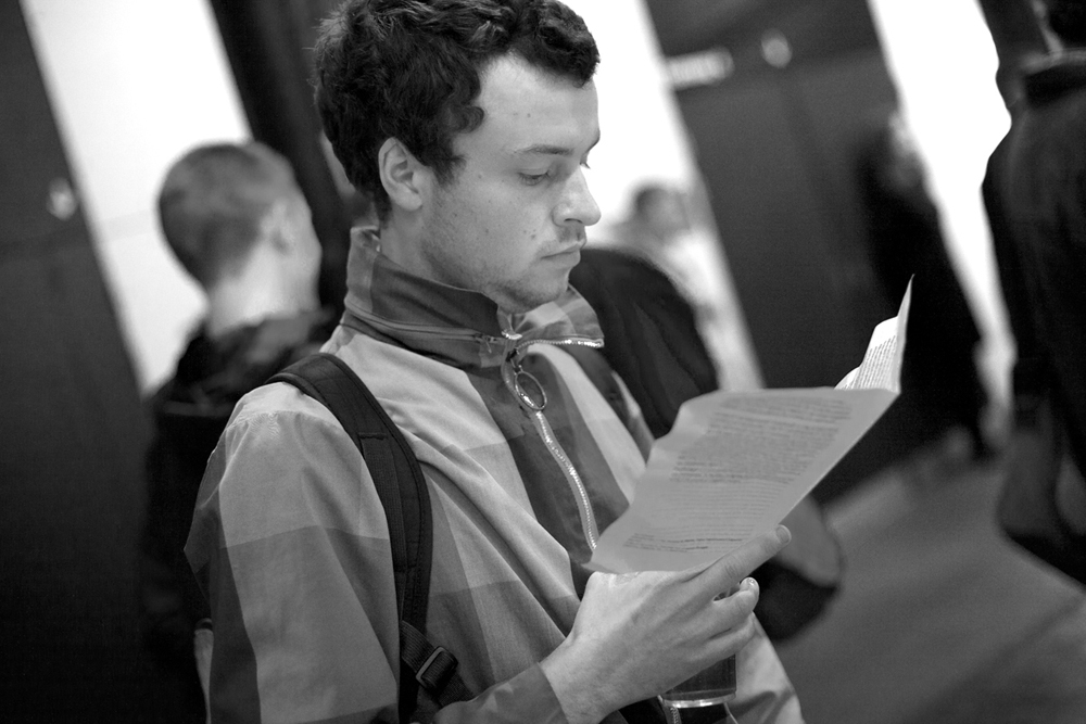 An audience member reads a handout in the foyer