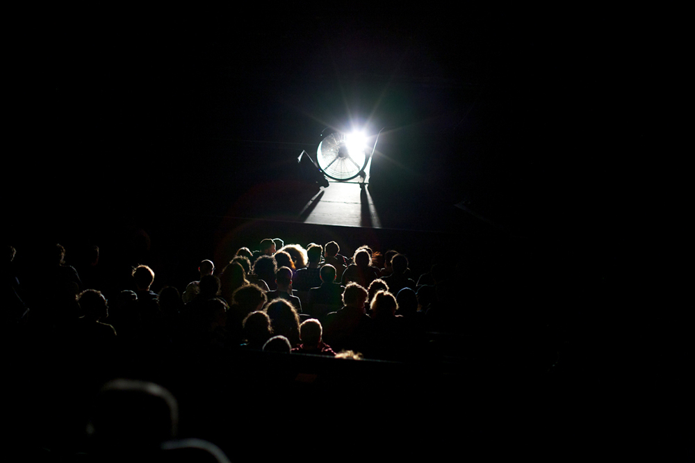 The audience is illuminated by a strong light and hit with wind from the fan