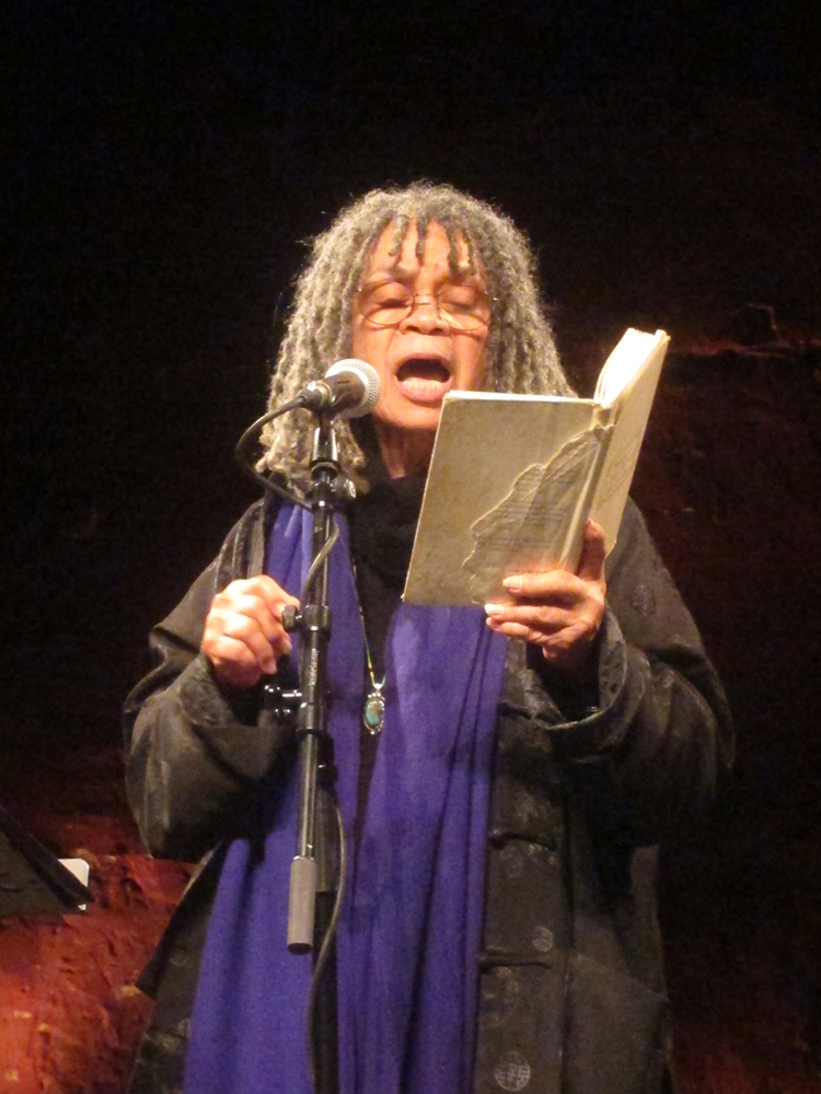 Sonia Sanchez gesticulates as she reads poetry with an open mouth