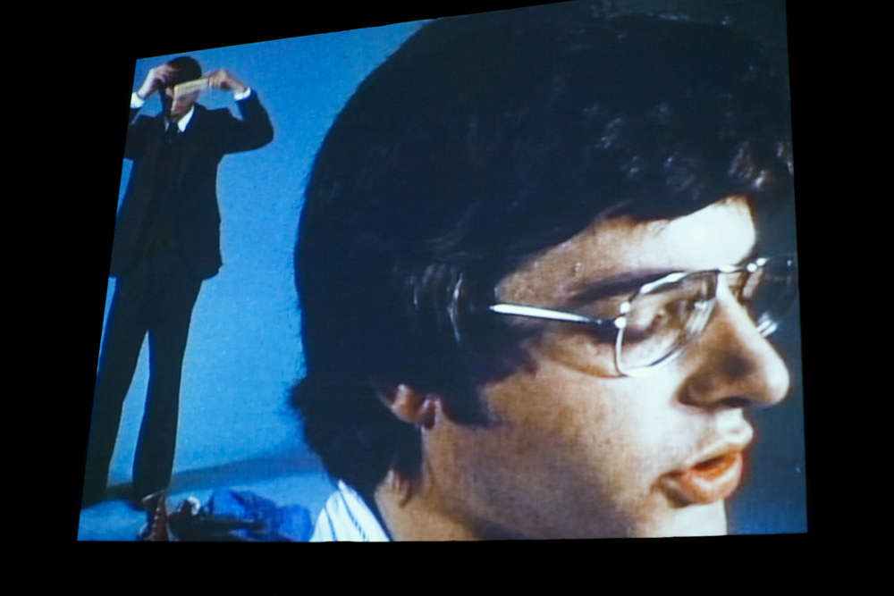 A shot of a screen showing the film Argument, a mans head reading off screen