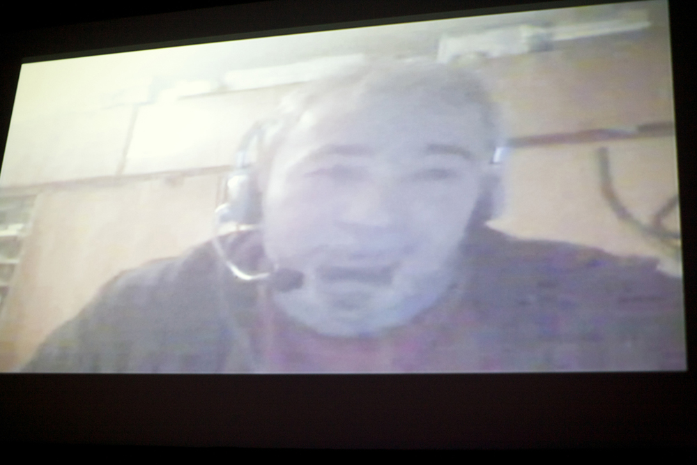 A fuzzy projected image of a Skype call with a member of Chto Delat
