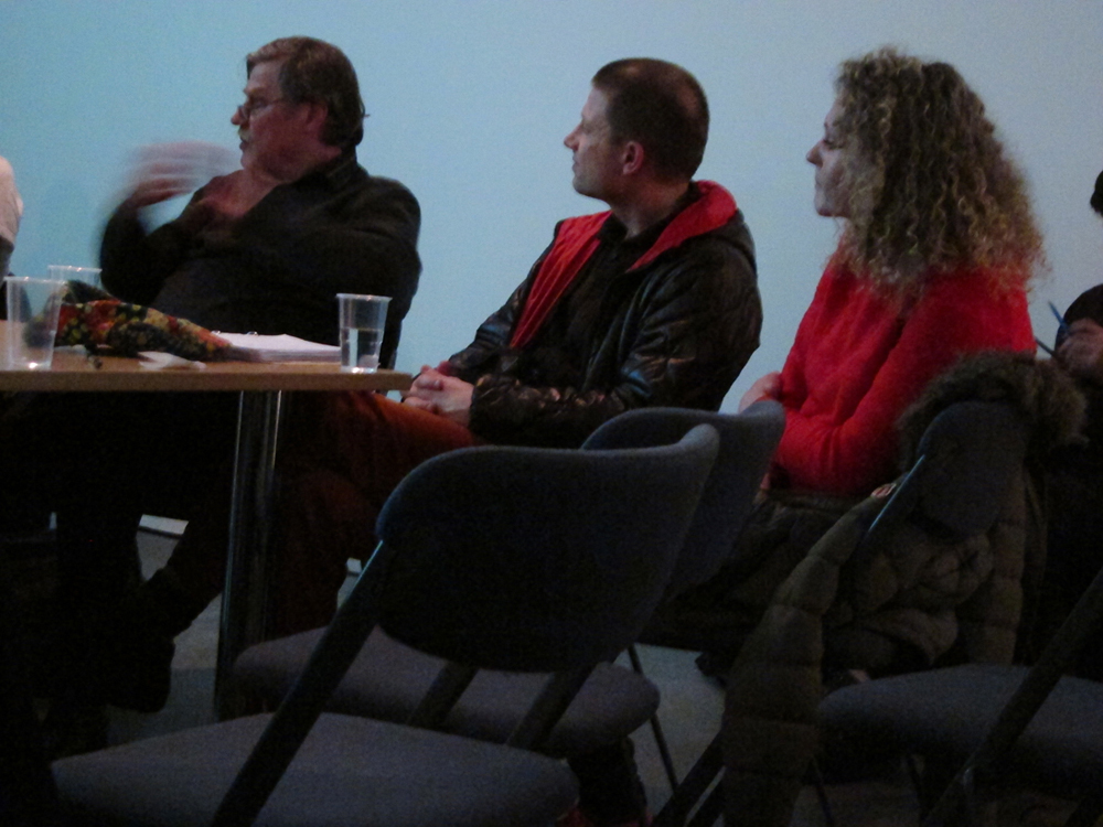 Hartmut Bitomsky gesticulates during a discussion with two audience members