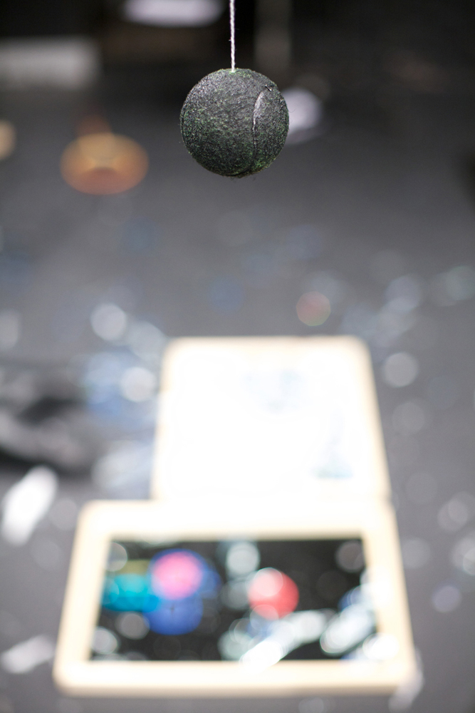 A shot of a black hanging ball, broken mirrors in the background