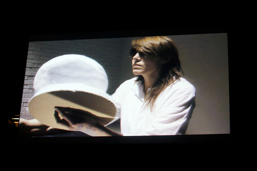 A shot of a screen showing Malin Arnell in sunglasses and a white outfit