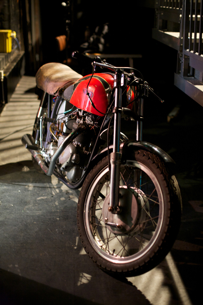 A red vintage motorcycle backstage, used as part of the performance