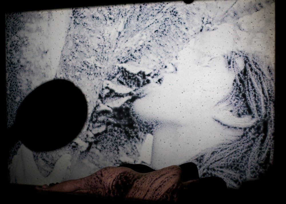 The back of naked figure is projected on with a black and white image