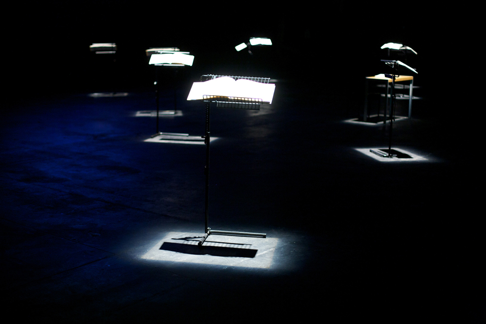 Pools of light show music stands holding large books