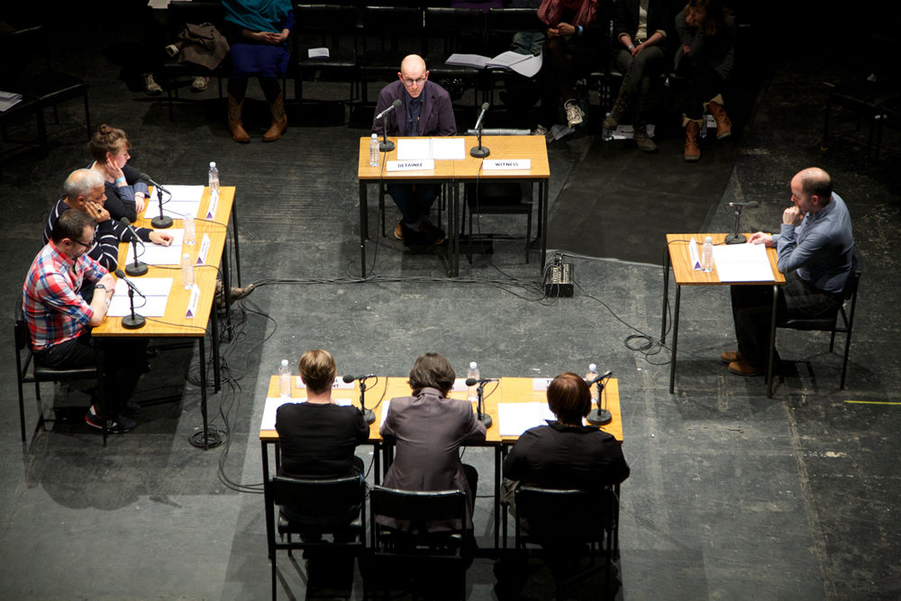 A shot from above showing all nine desks and eight participants sat at them