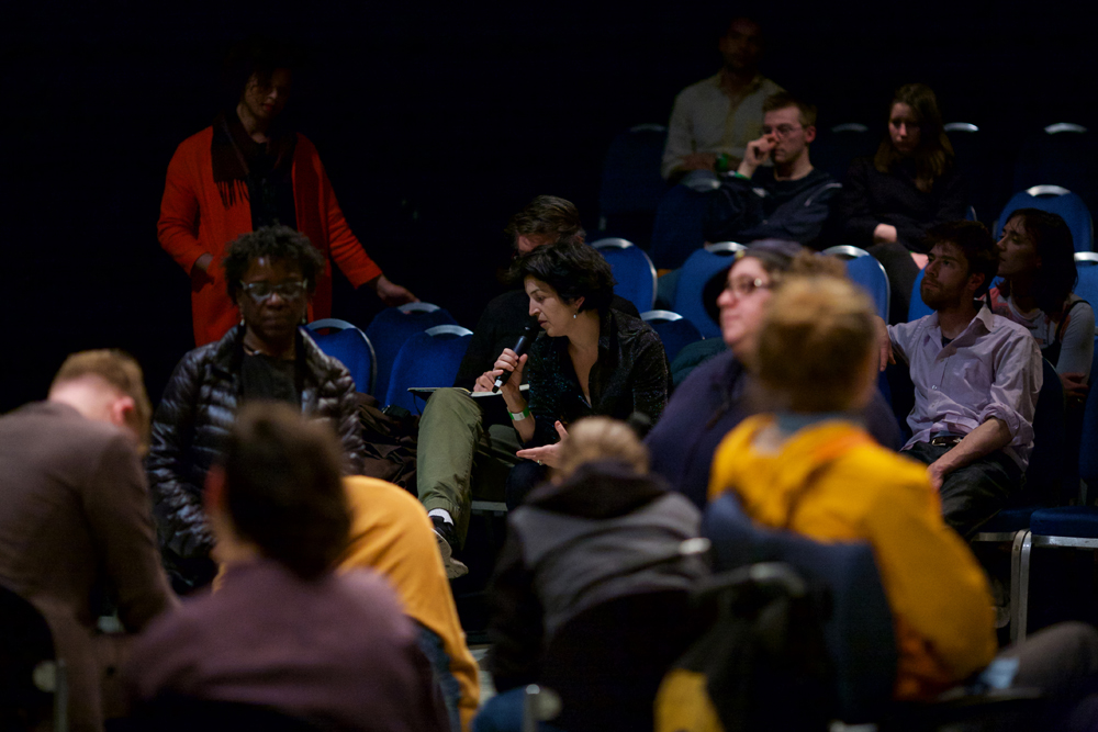 A member of the audience in profile asking a question