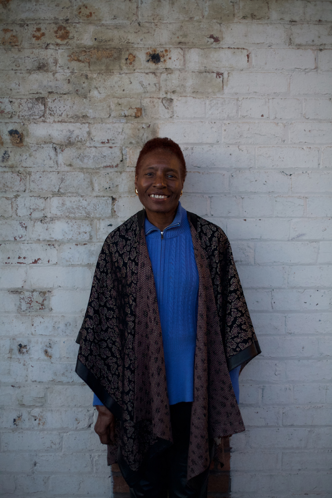 Hortense Spillers in blue and leather smiles at camera during a portrait