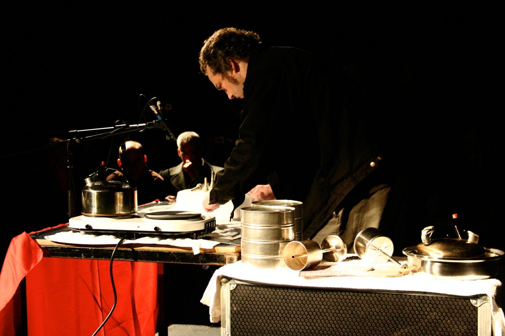 Michael Colligan is hunched over a table of objects and a lump of dry ice