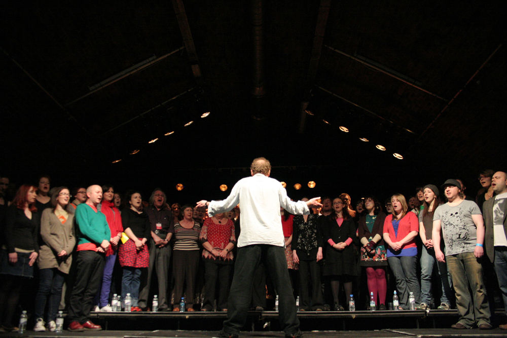 Phil Minton conducts a large choir