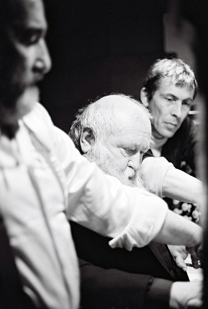 Hermann Nitsch plays organ flanked by two assistants