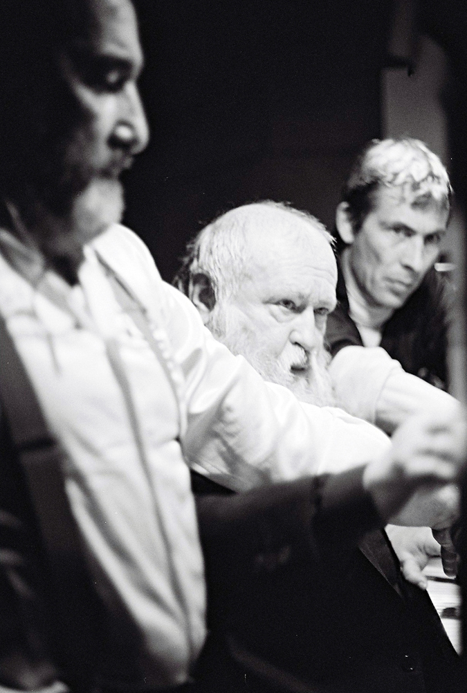 Hermann Nitsch plays organ flanked by two assistants