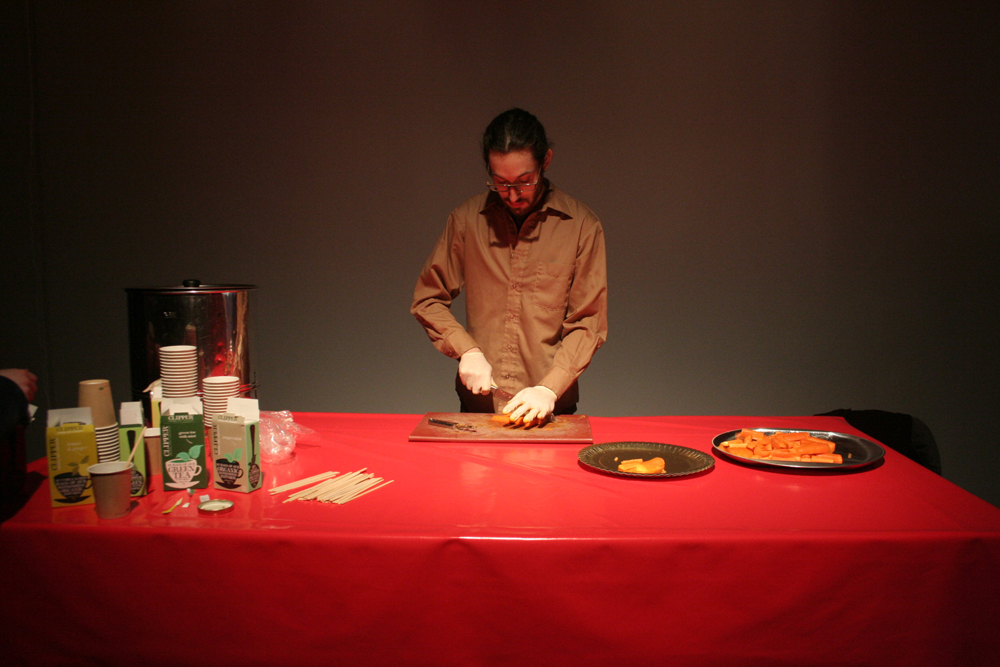 a man stands behind a red table