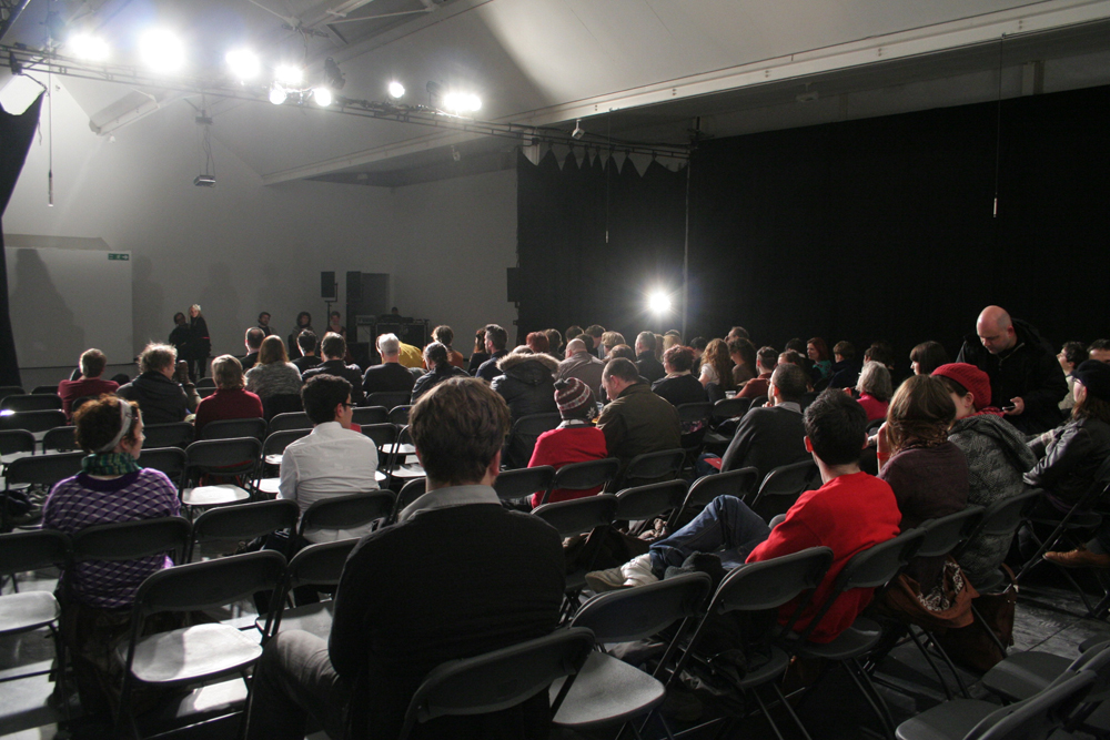 A back shot of a brightly lit audience