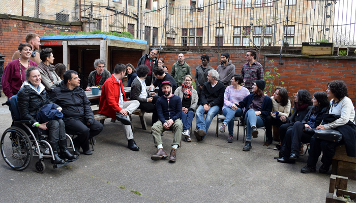 A large group of people in a yard smile at the camera