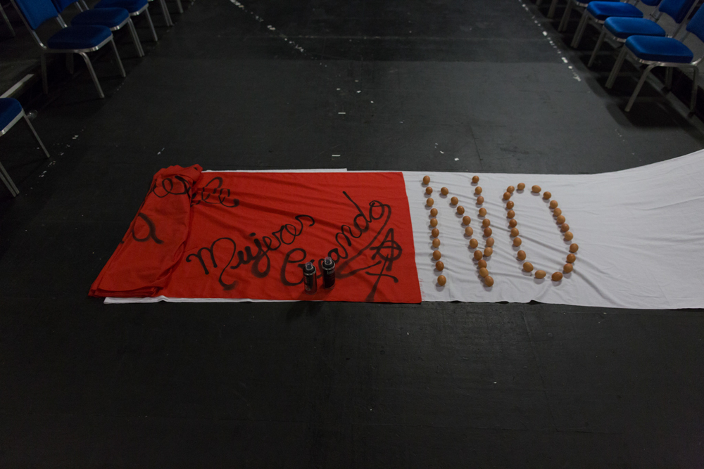 A red flag lies on top of a white sheet. Eggs are laid out to spell NO