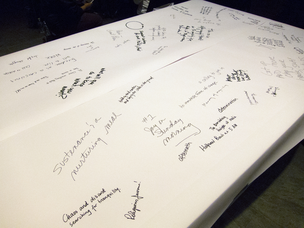 A table covered in white paper has been written on with marker pen