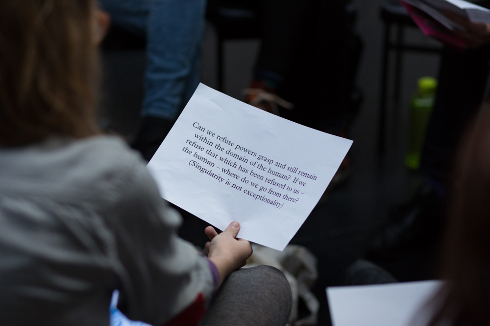 Someone holds and reads text on a paper as part of a group workshop