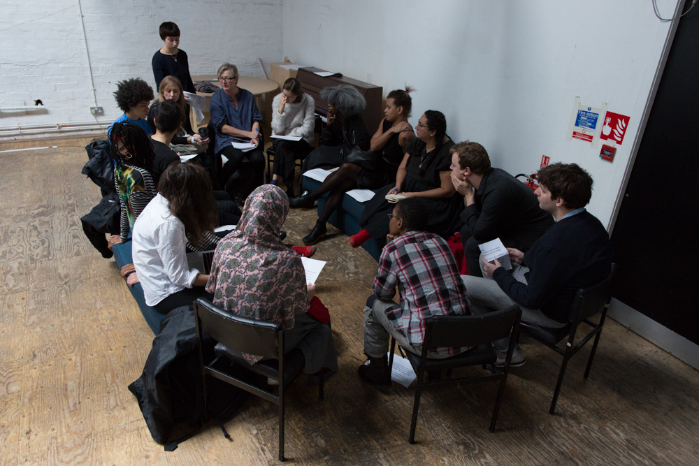 A group of people have a discussion in a workshop