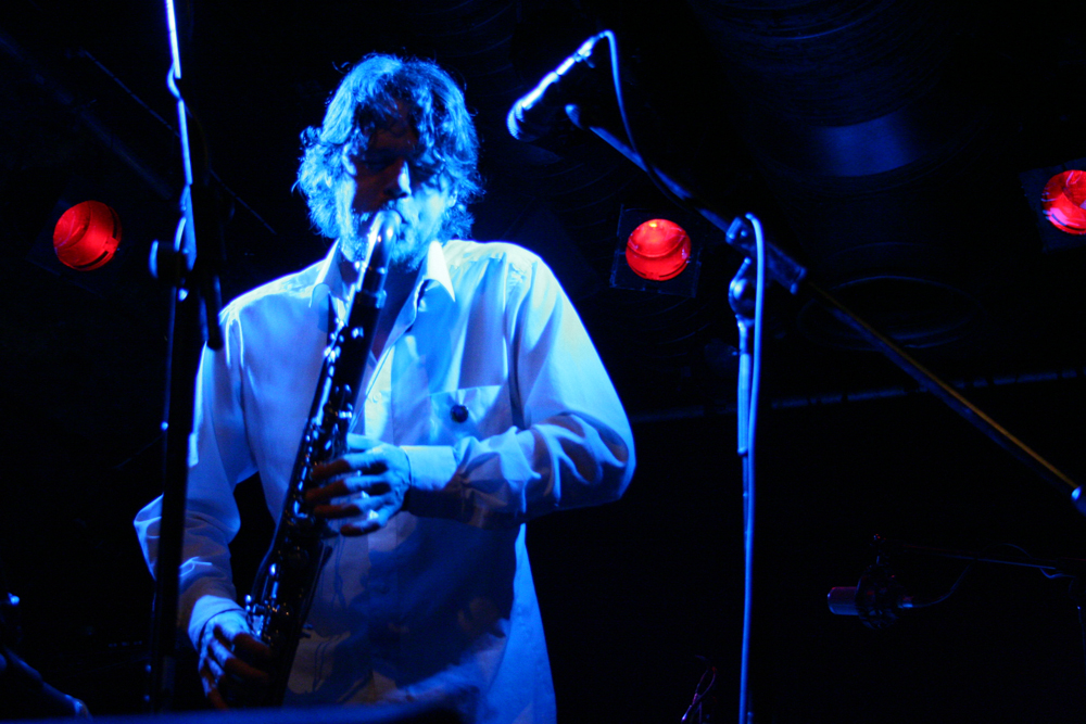Arrington plays a bass clarinet in blue light at INSTAL 06