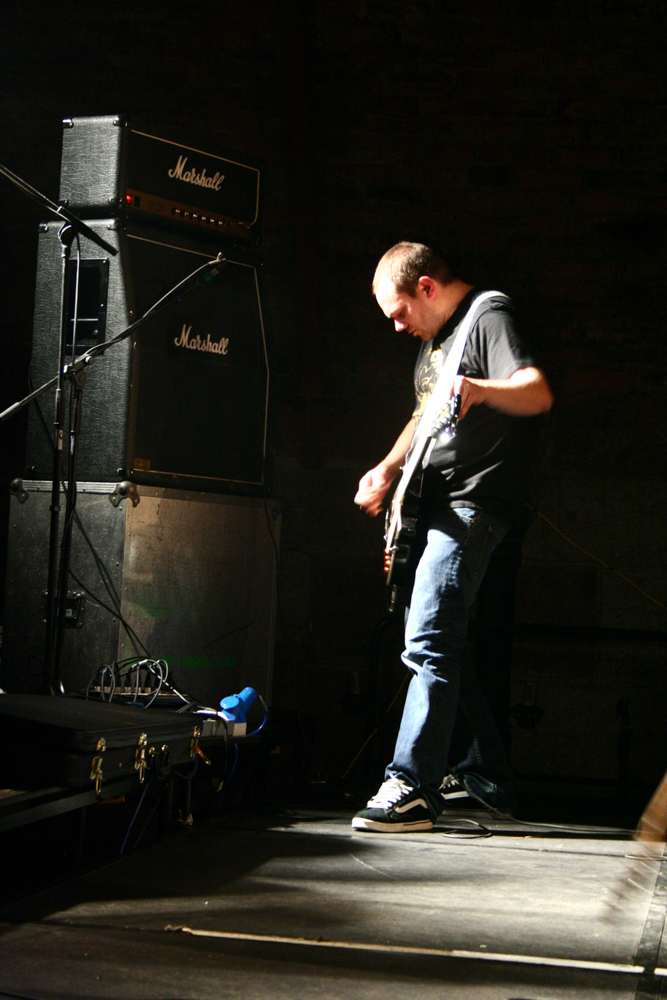 Jazkamer guitarist facing an amplifier