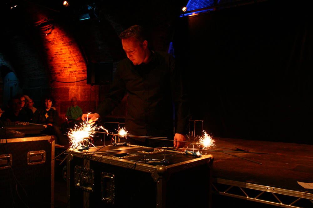 Lee Patterson standing at a table with sparklers burning on stands