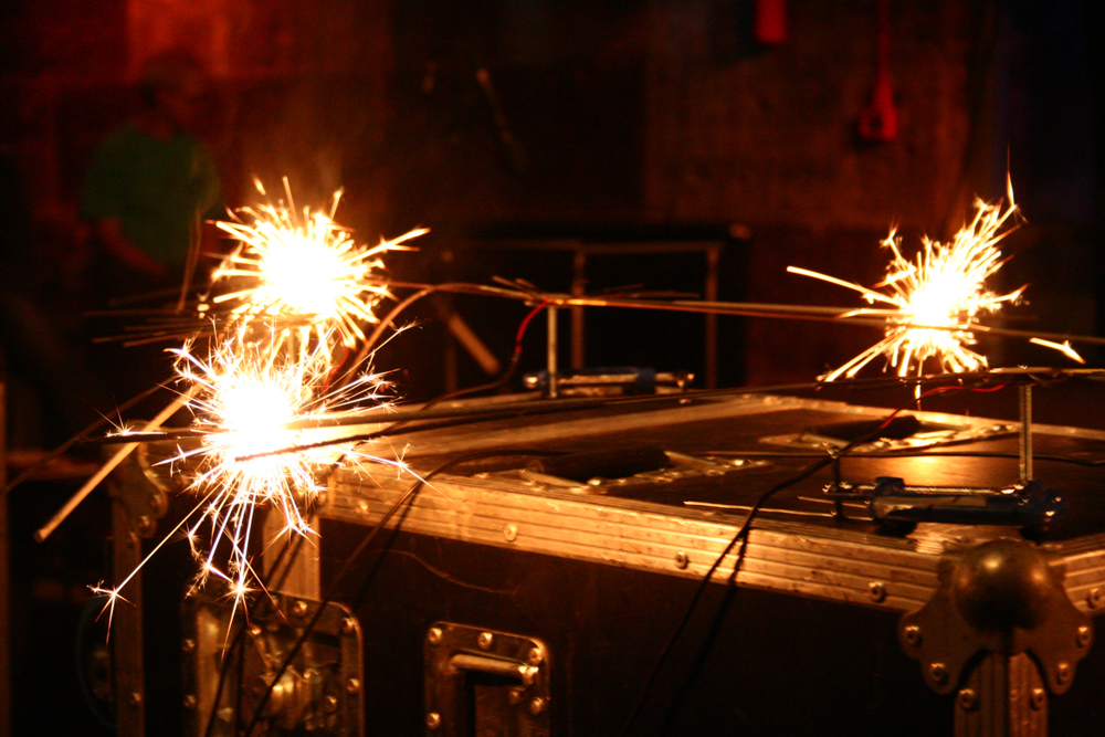 Sparklers mounted on stands with microphones being lit with a gas burner