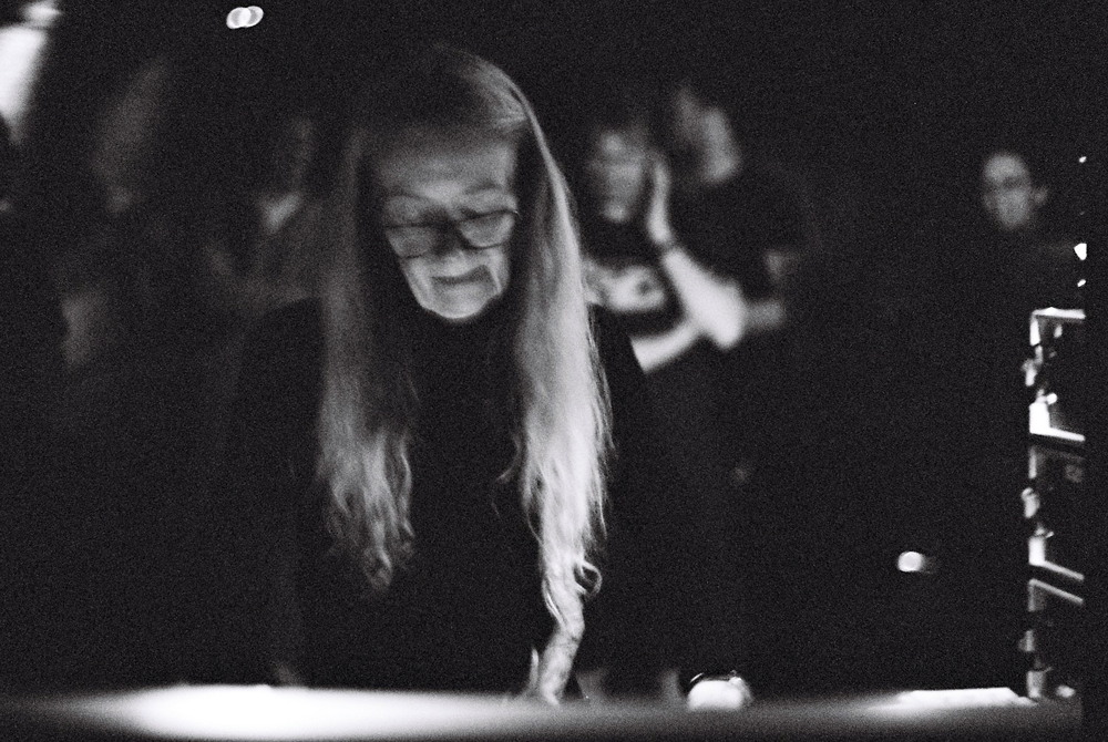 Maryanne Amacher operating a mixing console, wearing glasses