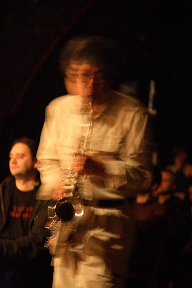 Tamio Shiraishi is a blurred figure as he plays a saxophone 