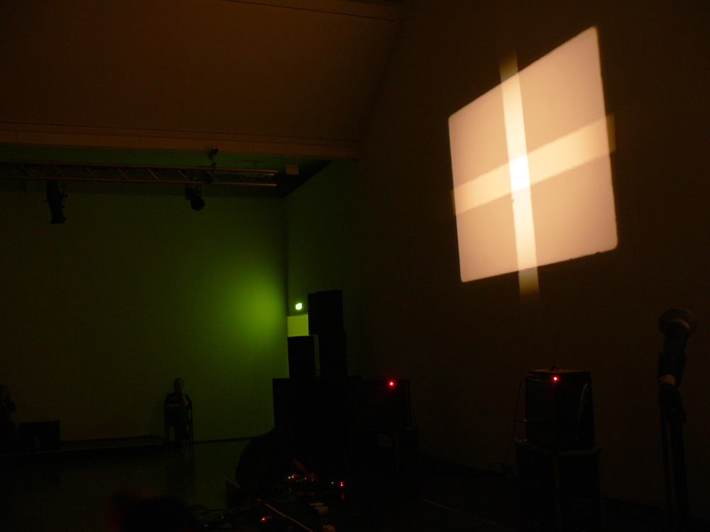 A screen showing a cross of light with some green shade in the foreground