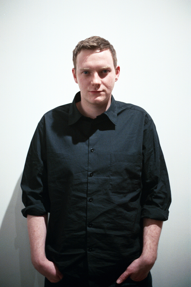 Portrait of Benedict Drew in a black shirt against a white background
