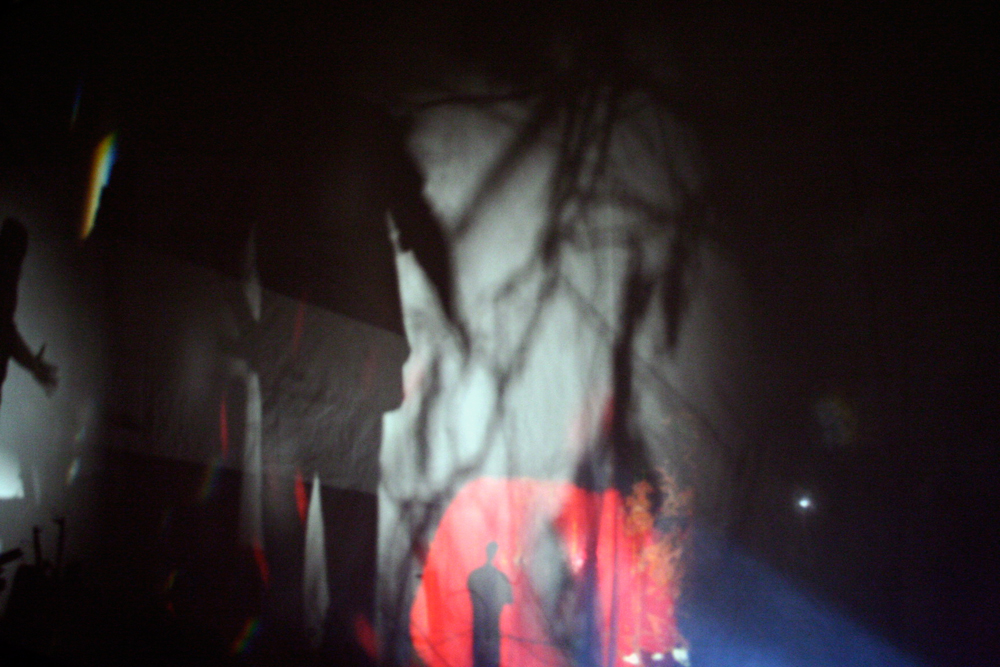 A figure of a person surrounded by red light at the bottom edge of a screen