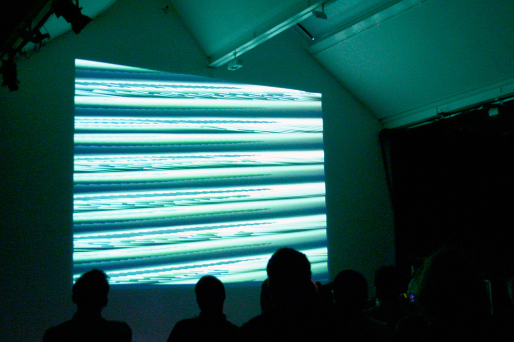 Projection of a distorted signal in blues and greens on a wall