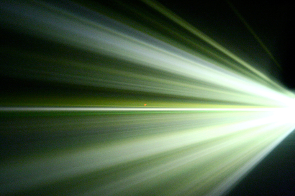 Beams of light fanning out from the right in bands of green and white