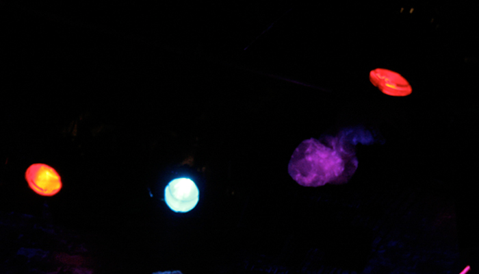 Three stage lights are seen in dark ceiling and a purple ghostly floating bag