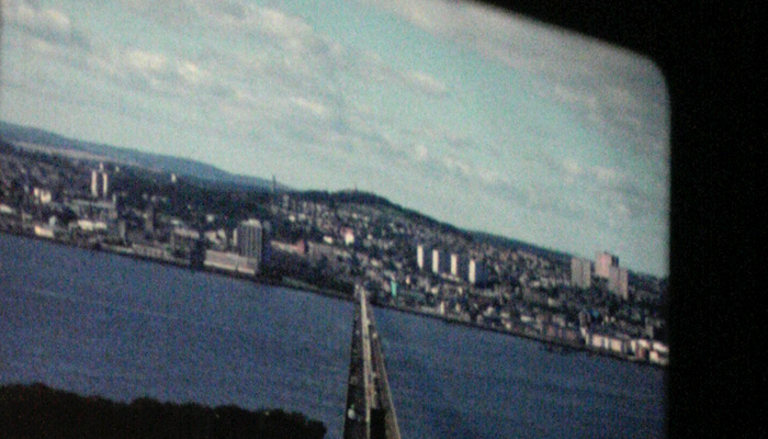 A shot of 16mm projection of the Tay Bridge straddling a sapphire blue river