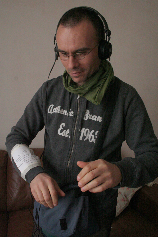 Eric La Casa wearing headphones and a list taped to his arm