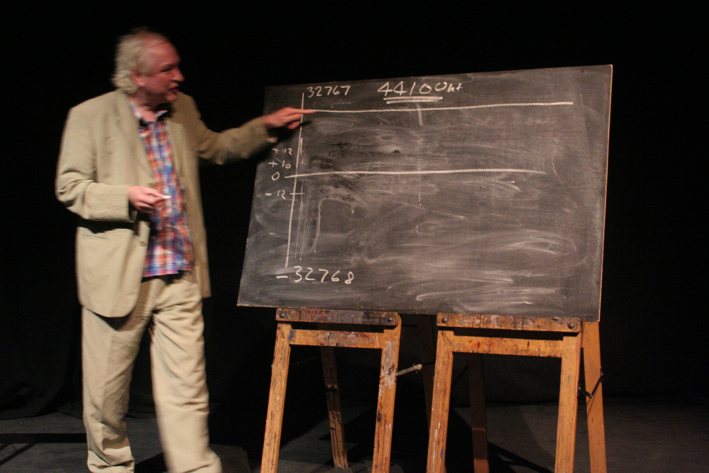 James Whitehead standing by a blackboard